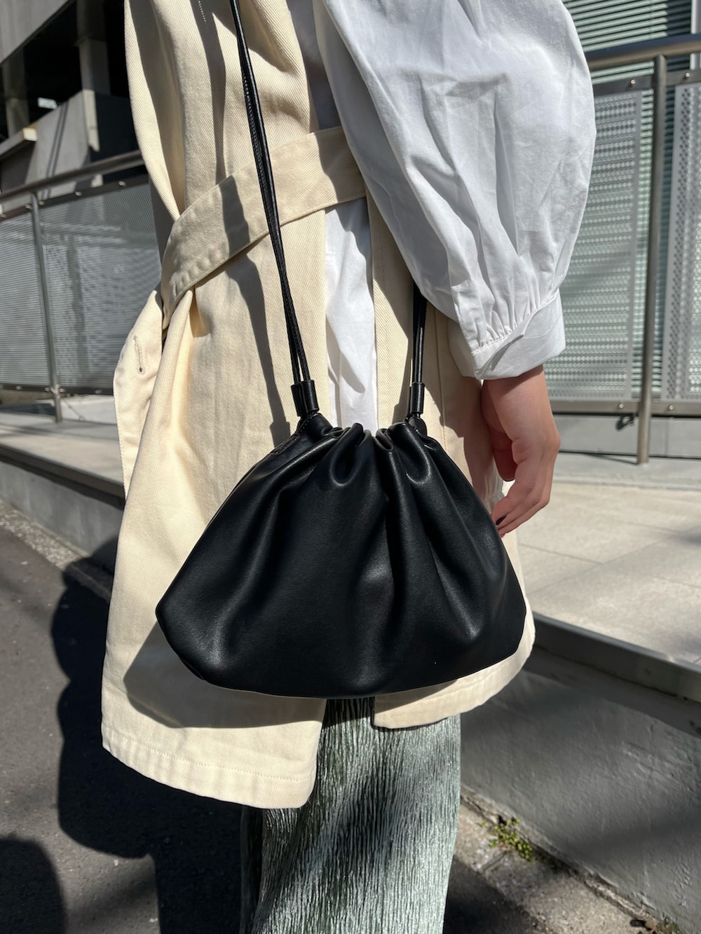 ブラック系のショルダーバッグ、ホワイト系のベスト、ホワイト系のシャツ/ブラウスを着用したレディースの冬コーディネートの3枚目の写真