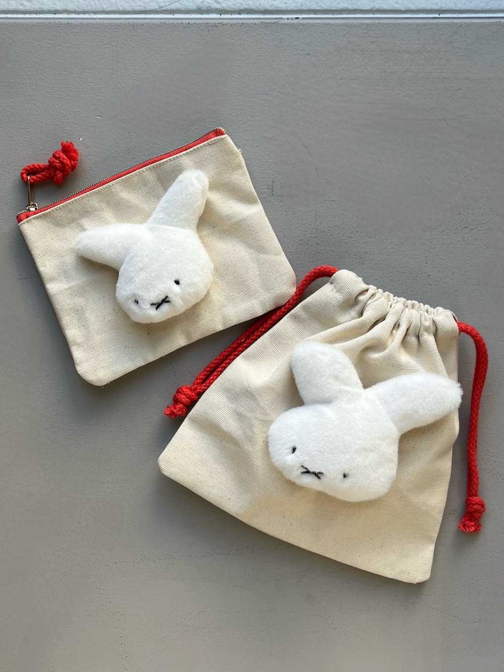 イエロー系の財布、レッド系のポーチ、ホワイト系のチャームを着用したレディースの夏コーディネートの2枚目の写真