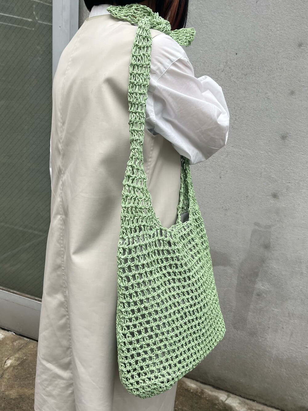 ブラック系のドレスシューズ、グリーン系のショルダーバッグ、ホワイト系のその他パンツを着用したレディースの春コーディネートの3枚目の写真