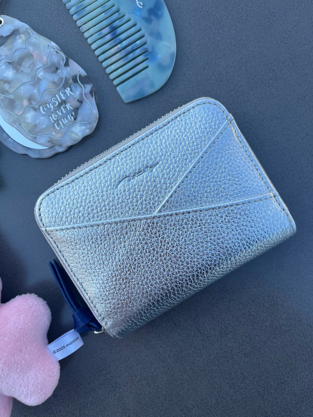 シルバー系の財布、ホワイト系の生活家電、ブルー系のヘアブラシを着用したレディースの春コーディネートの2枚目の写真