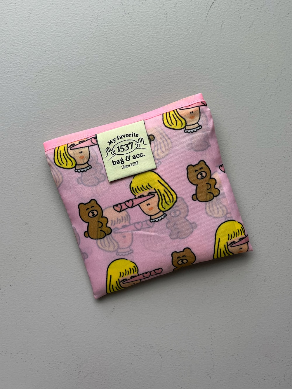 ピンク系のエコバッグ/サブバッグ、グリーン系のポーチ、ベージュ系のチャームを着用したレディースの夏コーディネートの4枚目の写真