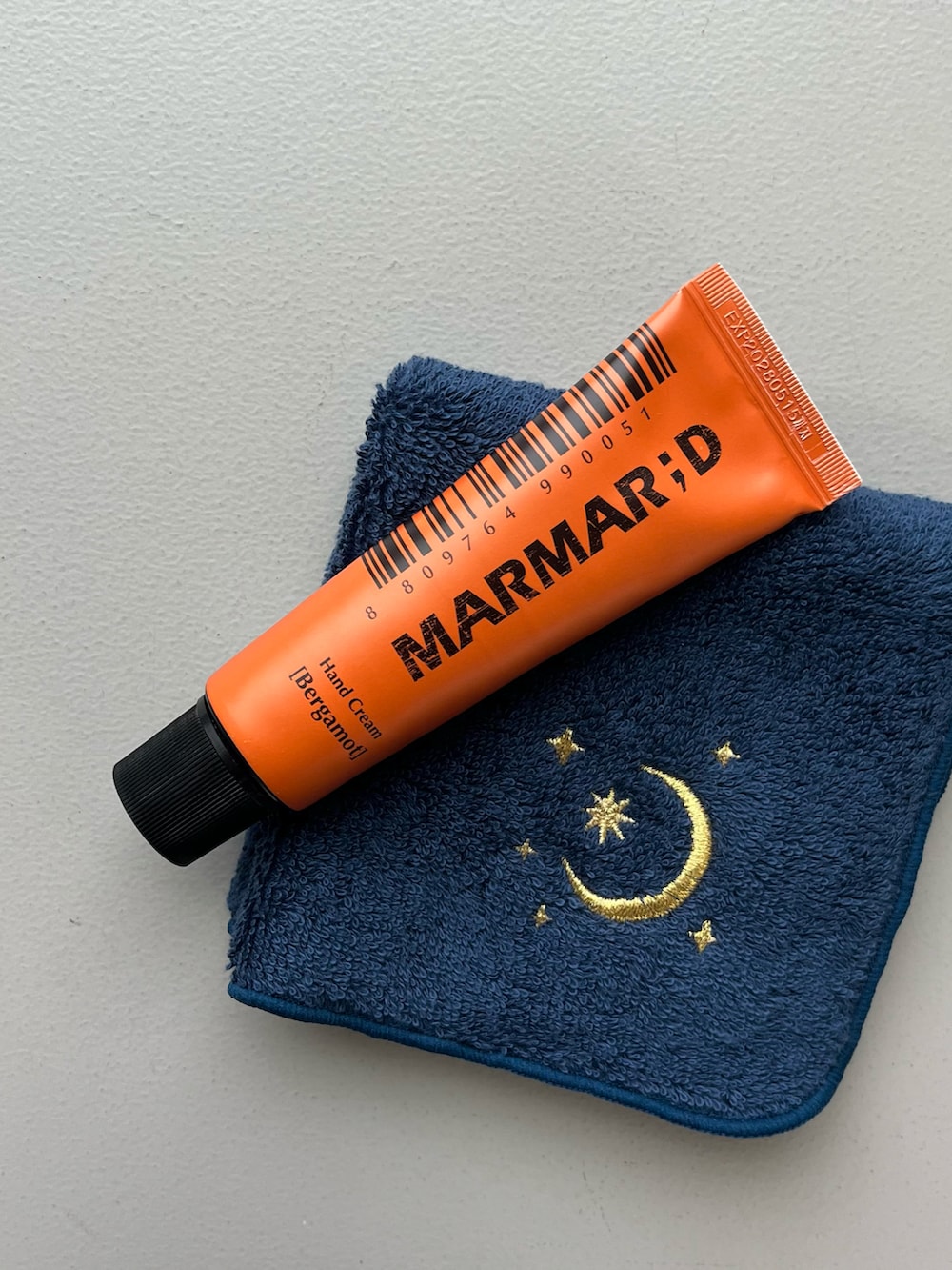 オレンジ系のポーチ、シルバー系の財布、ブラウン系のチャームを着用したレディースの冬コーディネートの4枚目の写真