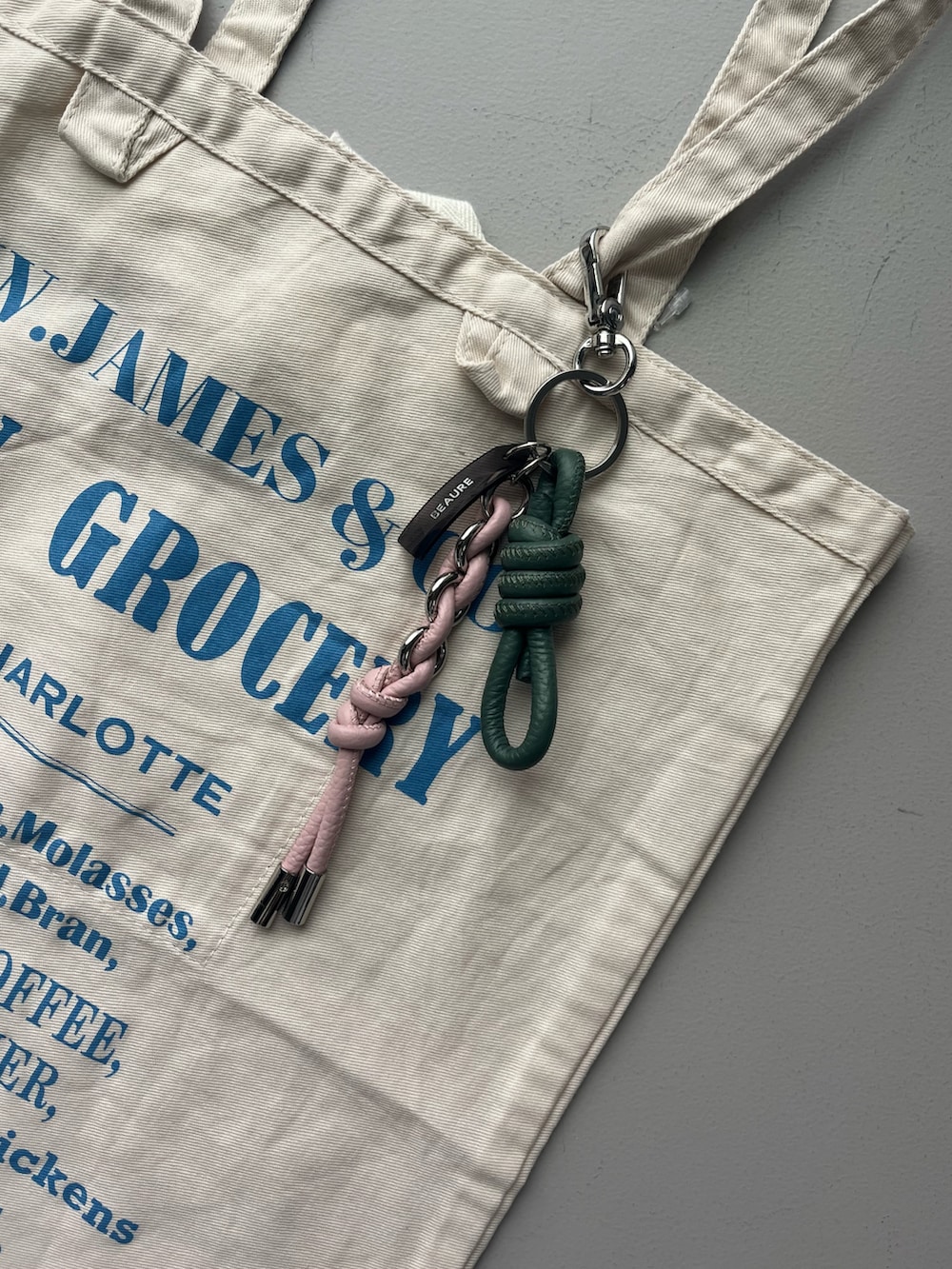 ホワイト系のエコバッグ/サブバッグ、グリーン系の折りたたみ傘、グリーン系のチャームを着用したレディースの夏コーディネートの5枚目の写真