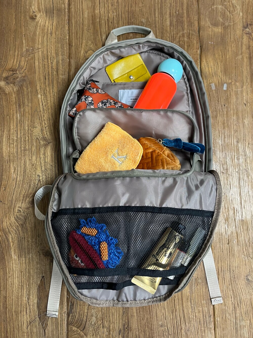 ベージュ系のバックパック/リュック、オレンジ系のスマホグッズ、グリーン系のスマホケース/カバーを着用したレディースの夏コーディネートの2枚目の写真