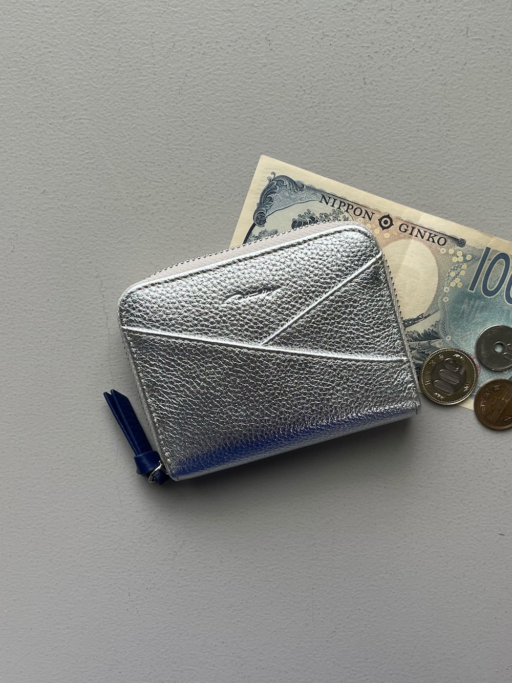 ホワイト系のハンドケア/ハンドクリーム、シルバー系の財布、ホワイト系のチャームを着用したレディースの秋コーディネートの2枚目の写真