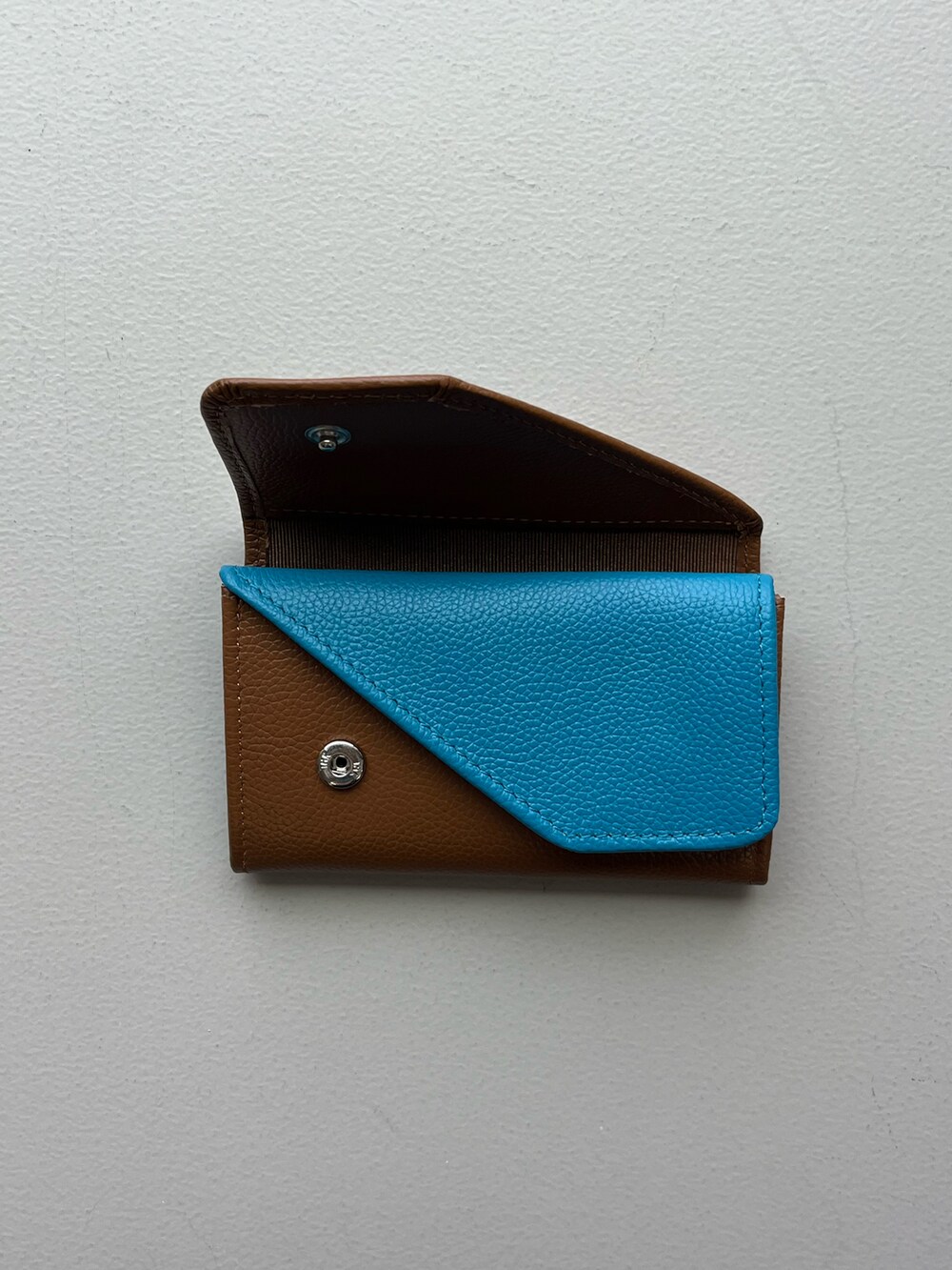 グリーン系の生活家電、イエロー系の名刺入れ、シルバー系の財布を着用したレディースの春コーディネートの2枚目の写真