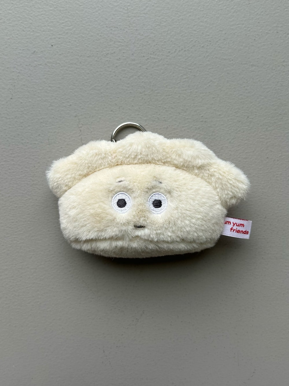 ホワイト系のチャーム、グレー系のポーチ、ピンク系のポーチを着用したレディースの春コーディネートの2枚目の写真