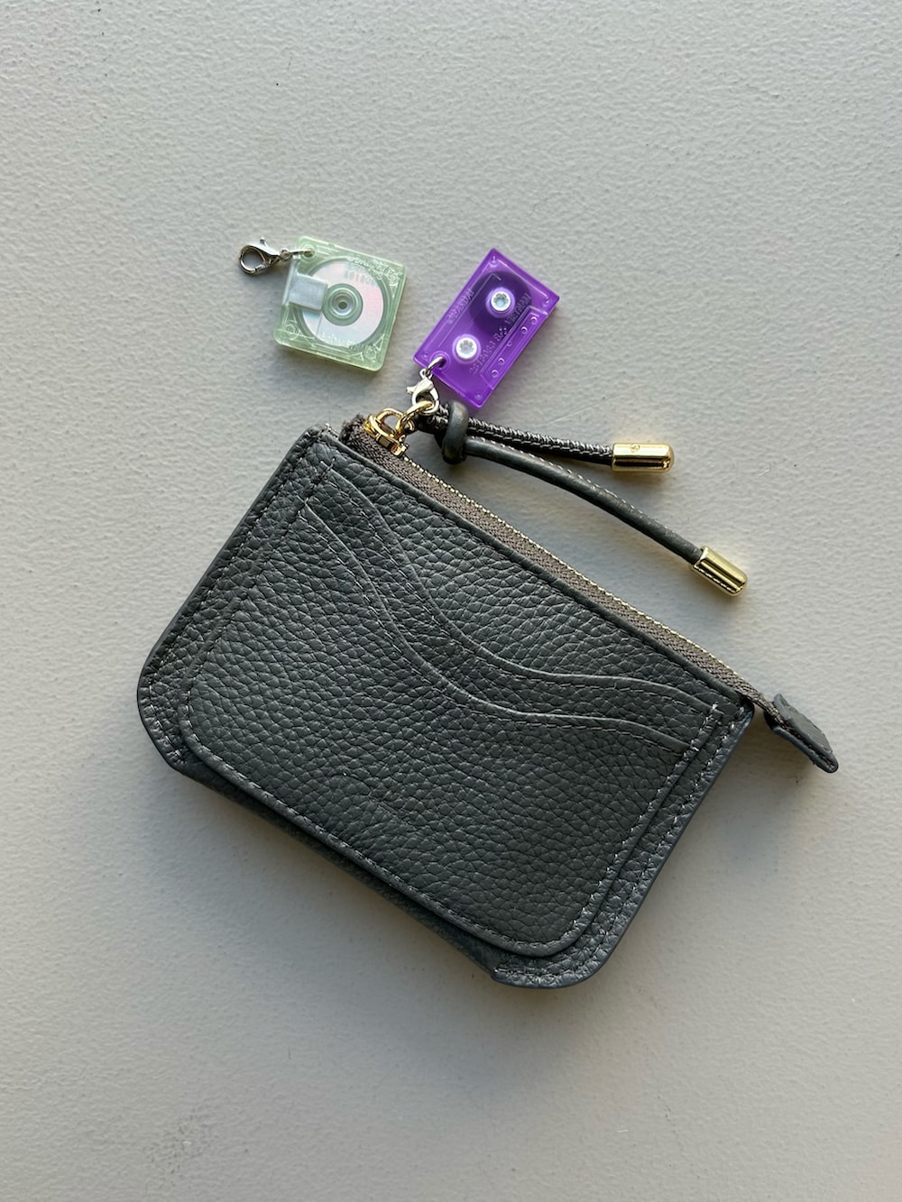 レッド系のポーチ、イエロー系の生活家電、ブルー系のチャームを着用したレディースの春コーディネートの5枚目の写真