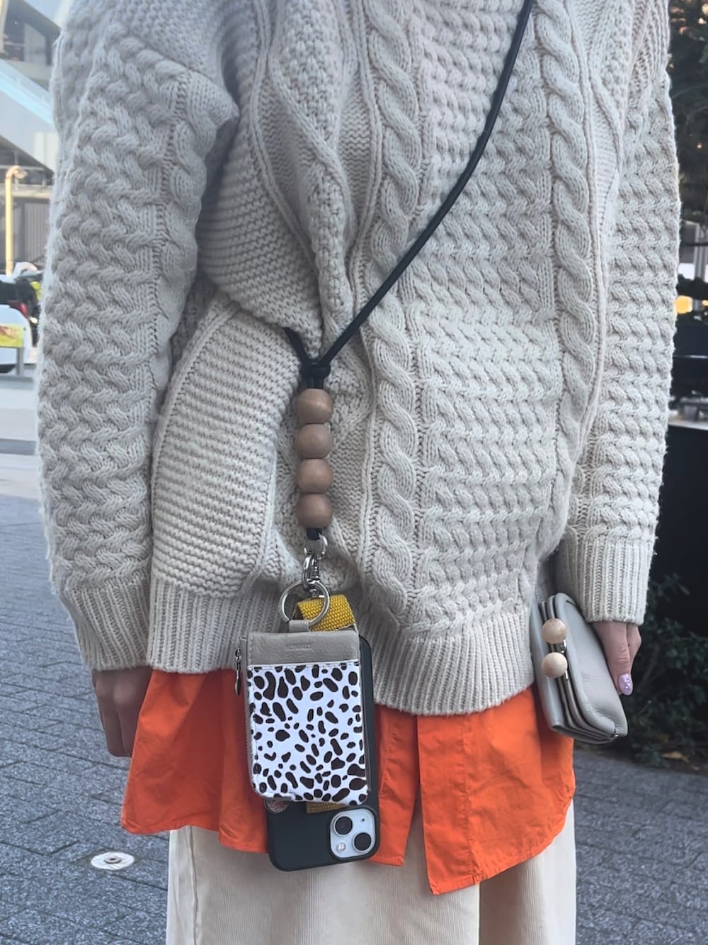 オレンジ系のシャツ/ブラウス、ブラック系のローファー、ベージュ系の財布を着用したレディースの冬コーディネートの2枚目の写真