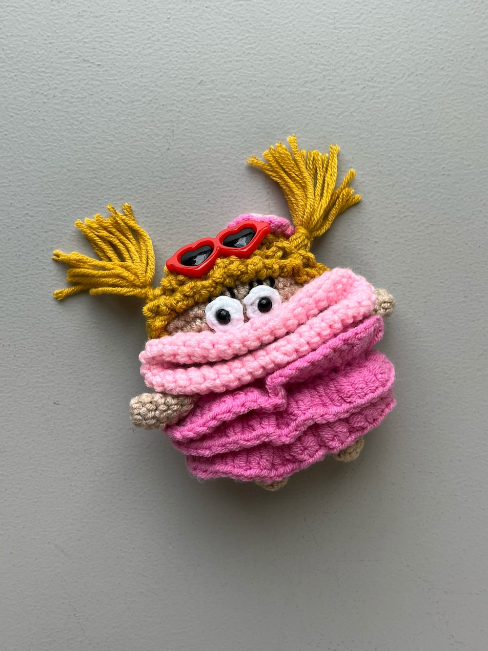 ブラック系のスマホグッズ、ゴールド系のパスケース、ピンク系の香水を着用したレディースの冬コーディネートの4枚目の写真