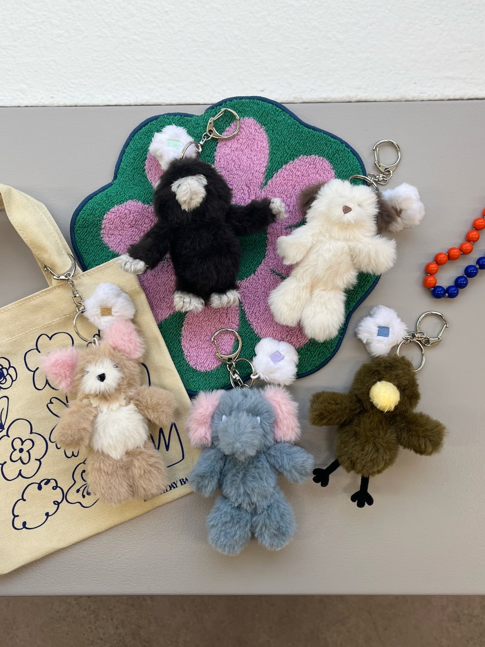 オレンジ系のトートバッグ、オレンジ系のポーチ、オレンジ系のスマホグッズを着用したレディースの春コーディネートの2枚目の写真