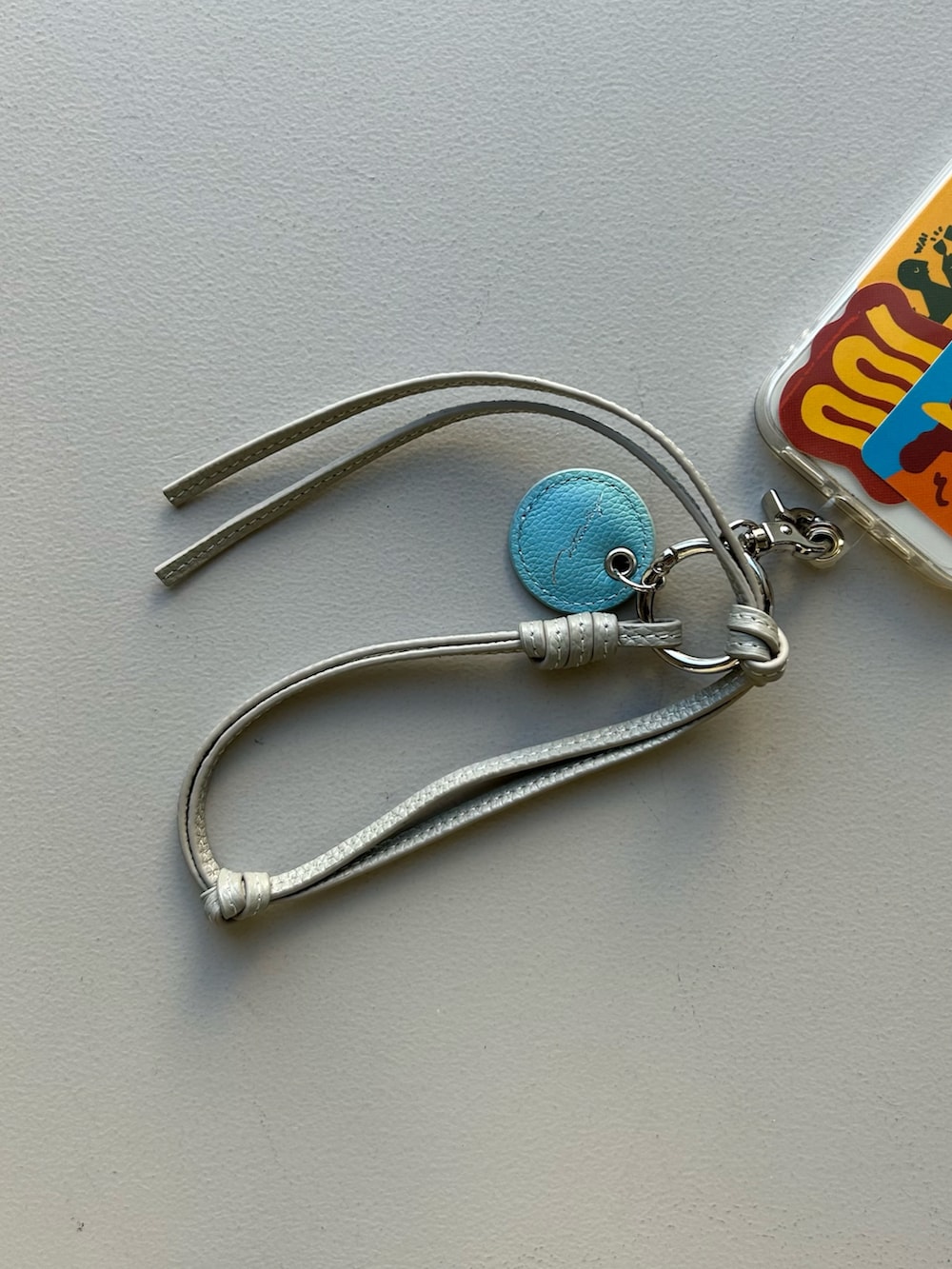 オレンジ系のエコバッグ/サブバッグ、ベージュ系の財布、グレー系のスマホグッズを着用したレディースの春コーディネートの4枚目の写真