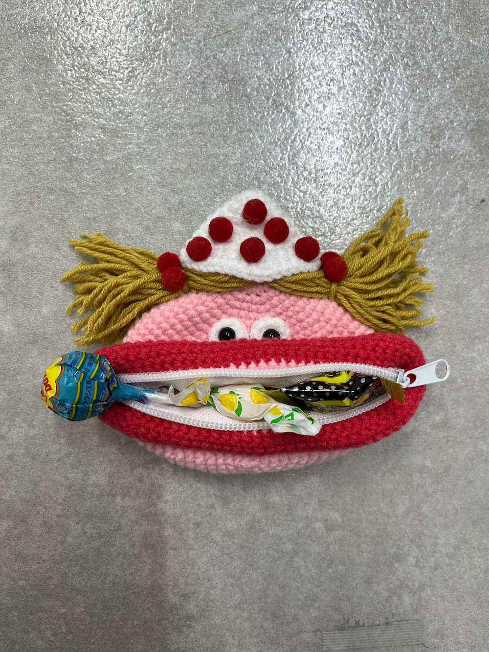 レッド系のポーチ、イエロー系のポーチ、ホワイト系のチャームを着用したレディースの冬コーディネートの2枚目の写真