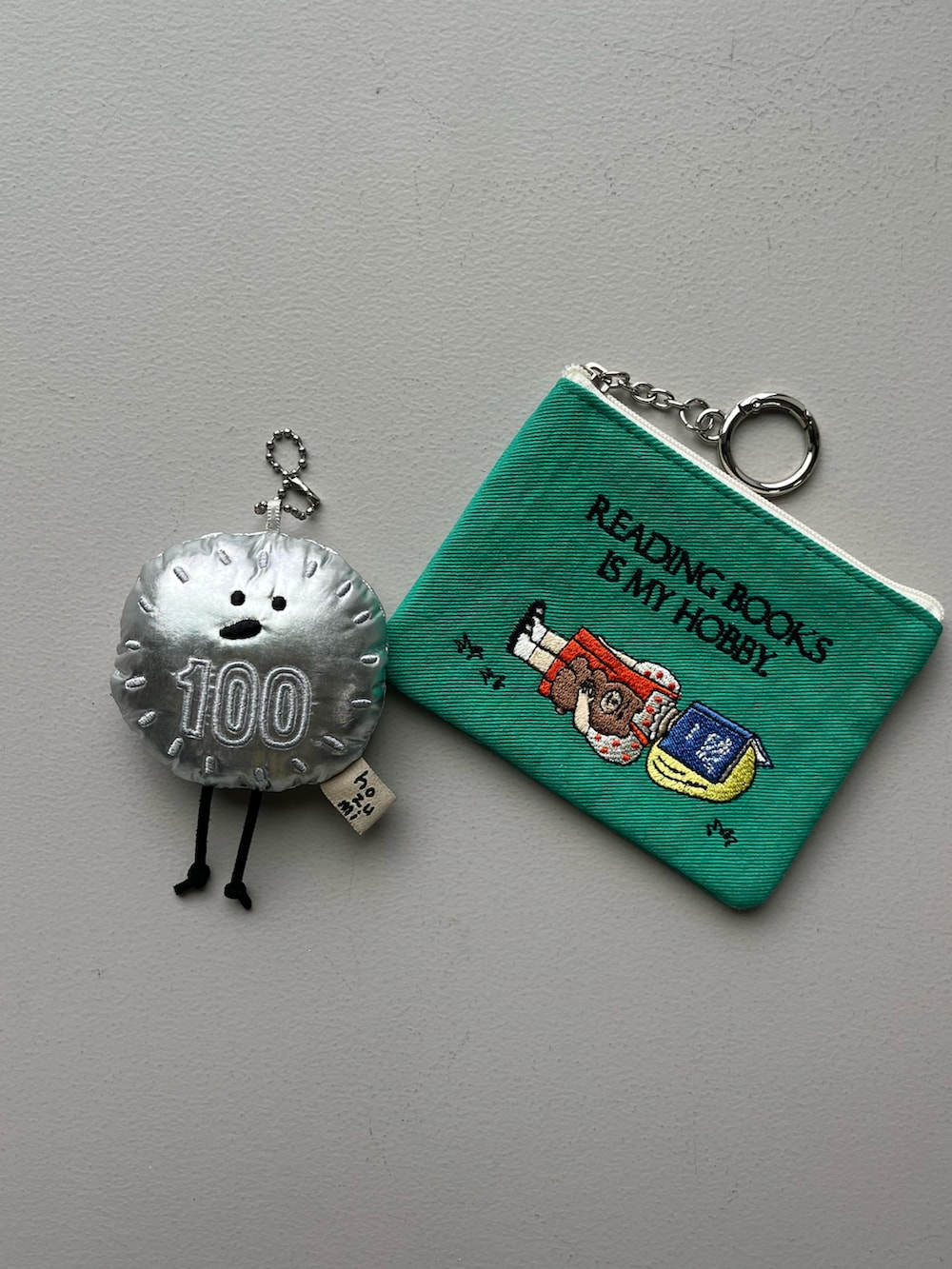 シルバー系のチャーム、ブルー系のパスケース、グリーン系のポーチを着用したレディースの冬コーディネートの5枚目の写真