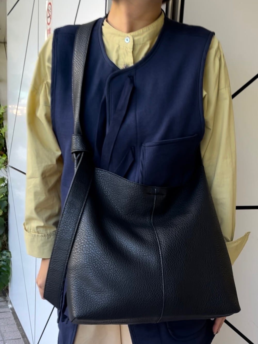 ブラック系のショルダーバッグ、ホワイト系のスニーカーを着用したレディースの秋コーディネートの3枚目の写真