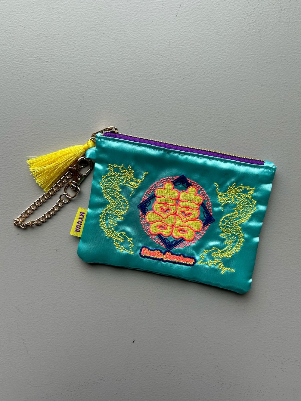 グリーン系の財布、ブラック系のポーチ、ブルー系のポーチを着用したレディースの春コーディネートの2枚目の写真