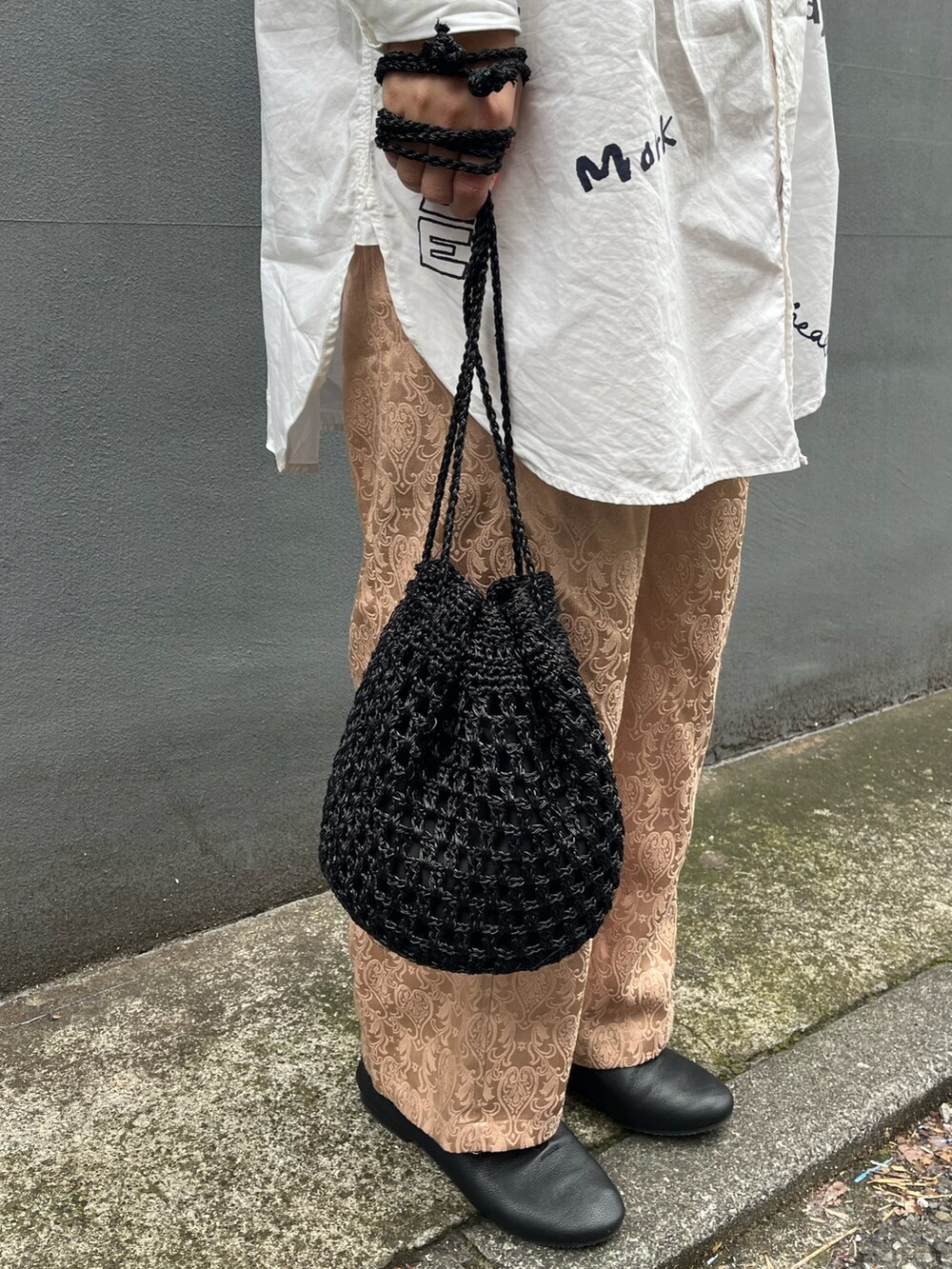 ブラック系のショルダーバッグ、ブラック系のドレスシューズ、ホワイト系のワンピースを着用したレディースの春コーディネートの2枚目の写真