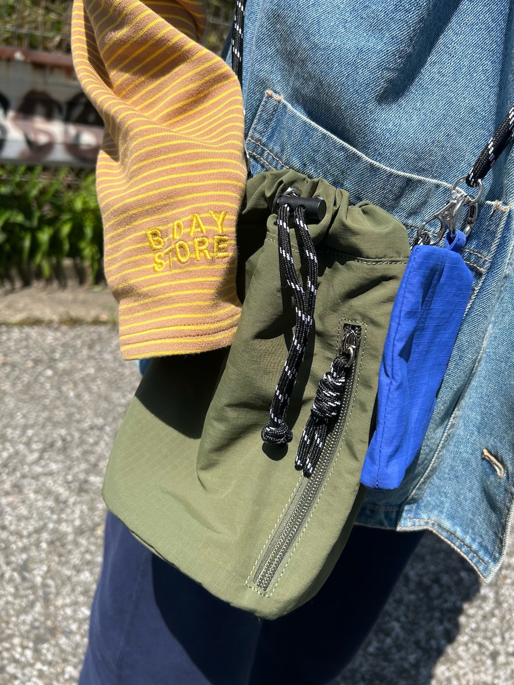 ブルー系のスウェットパンツ、イエロー系のTシャツ/カットソー、ブルー系のベストを着用したレディースの春コーディネートの2枚目の写真