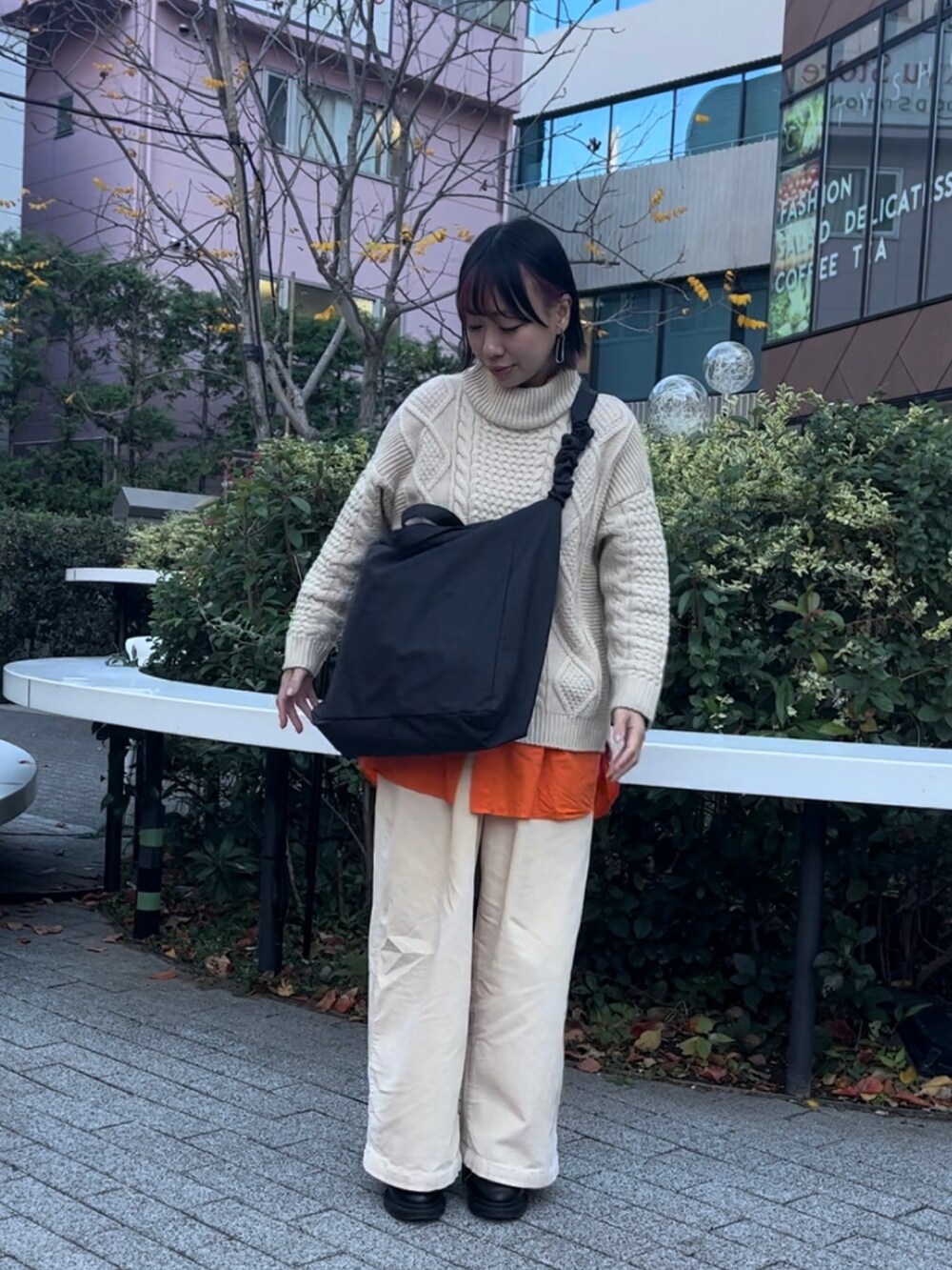 ブラック系のトートバッグ、オレンジ系のシャツ/ブラウス、ブラック系のローファーを着用したレディースの秋コーディネートの2枚目の写真