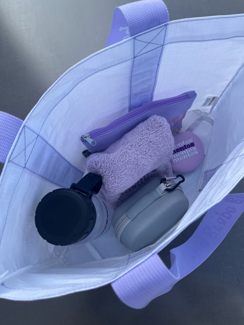 パープル系のトートバッグ、グレー系の生活家電、パープル系の水筒を着用したレディースの夏コーディネートの2枚目の写真