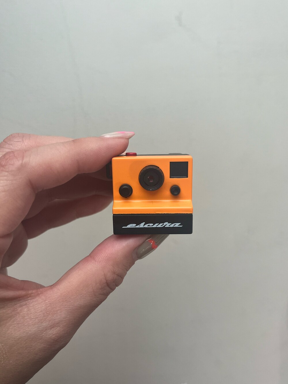 ホワイト系のポーチ、イエロー系の財布、オレンジ系のチャームを着用したレディースの春コーディネートの5枚目の写真