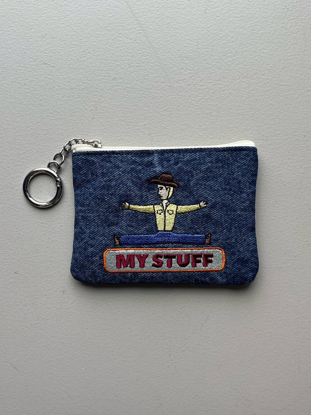 グリーン系の財布、ブルー系のポーチ、シルバー系のチャームを着用したレディースの夏コーディネートの2枚目の写真