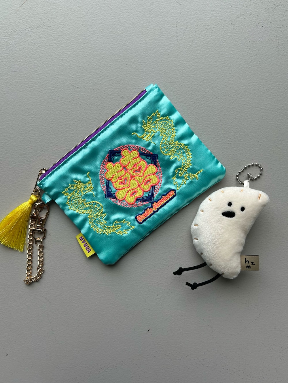 グリーン系の財布、ブラック系のポーチ、ブルー系のポーチを着用したレディースの春コーディネートの3枚目の写真