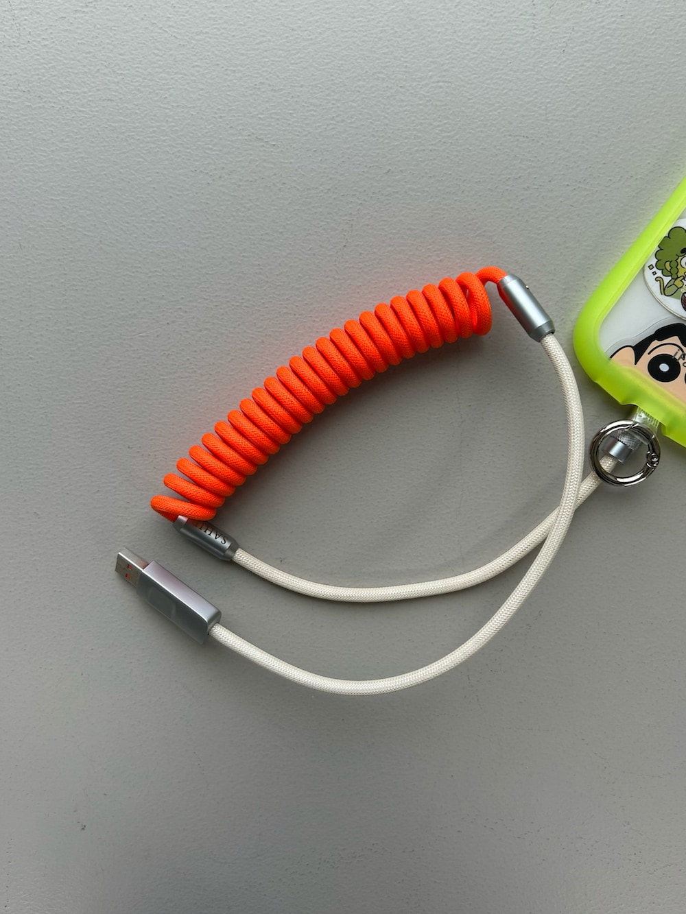 オレンジ系のポーチ、シルバー系の財布、ブラウン系のチャームを着用したレディースの冬コーディネートの5枚目の写真