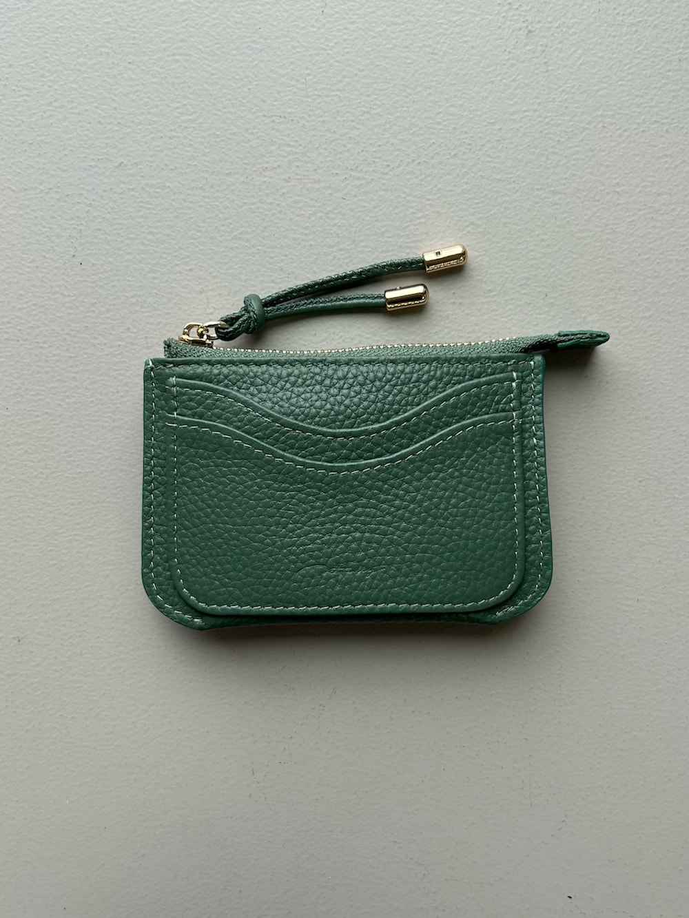 ホワイト系のチャーム、グレー系のポーチ、ピンク系のポーチを着用したレディースの春コーディネートの4枚目の写真