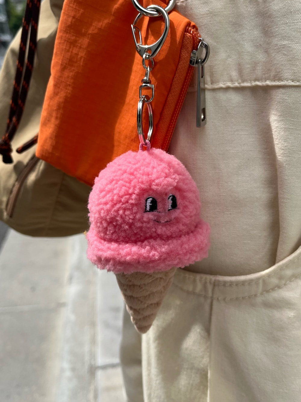 ホワイト系のスニーカー、ベージュ系のショルダーバッグ、ピンク系のチャームを着用したレディースの夏コーディネートの3枚目の写真