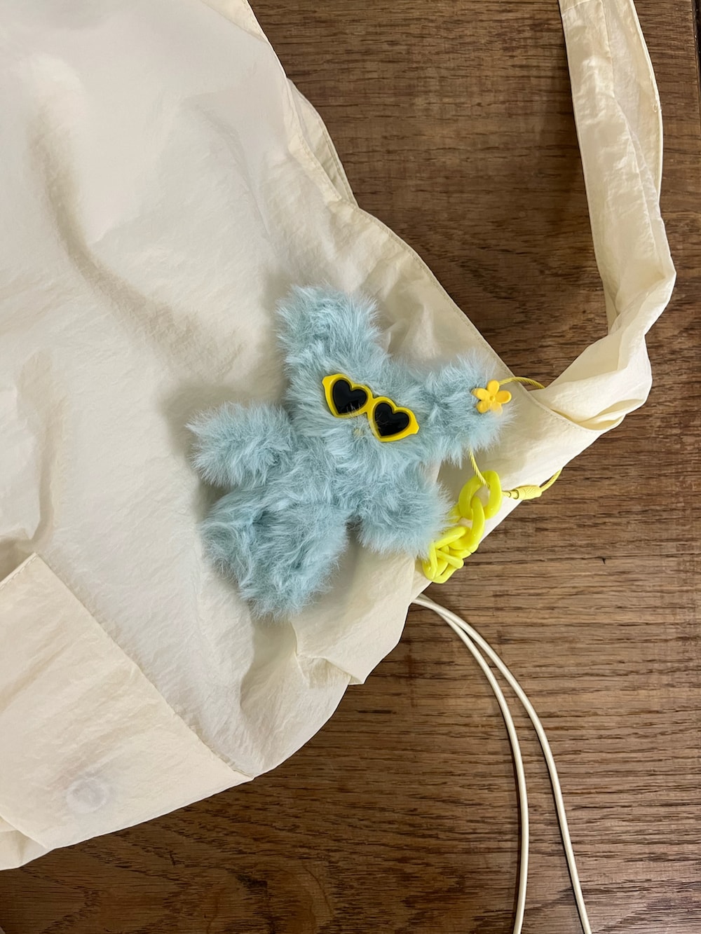 ホワイト系のトートバッグ、ブラウン系のキーホルダーを着用したレディースの秋コーディネートの2枚目の写真