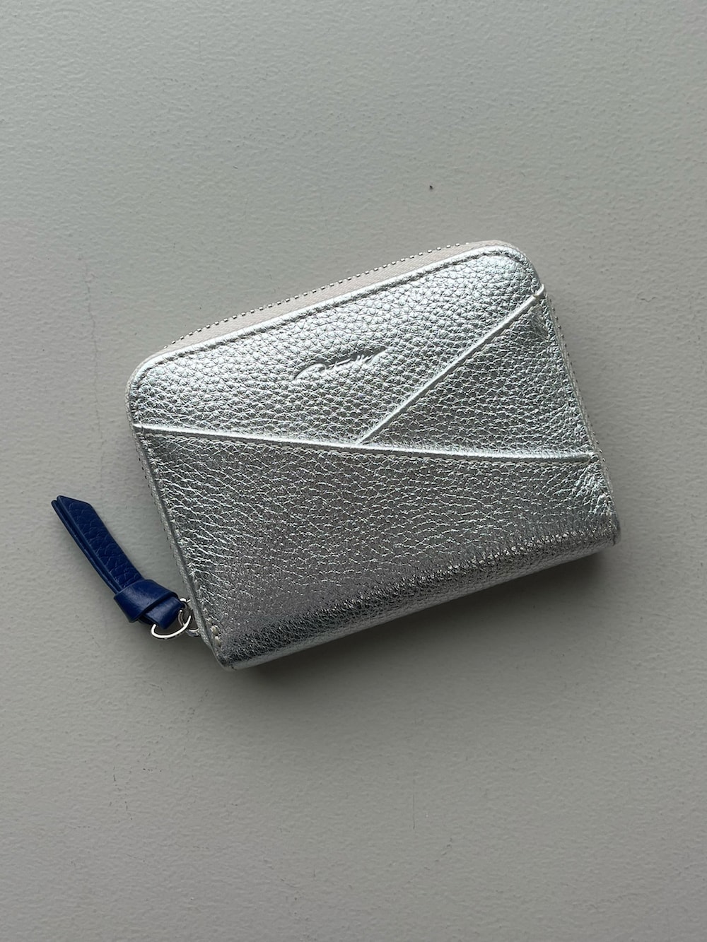 ブルー系のポーチ、グリーン系の財布、シルバー系のポーチを着用したレディースの夏コーディネートの2枚目の写真