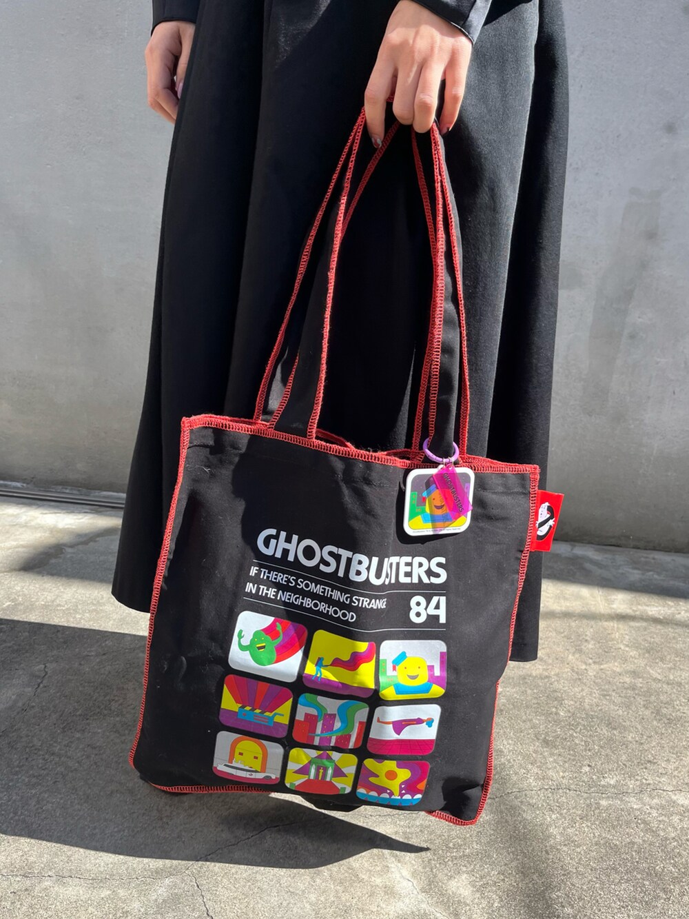 ホワイト系のスニーカー、ブラック系のスカート、ブラック系のトートバッグを着用したレディースの春コーディネートの3枚目の写真