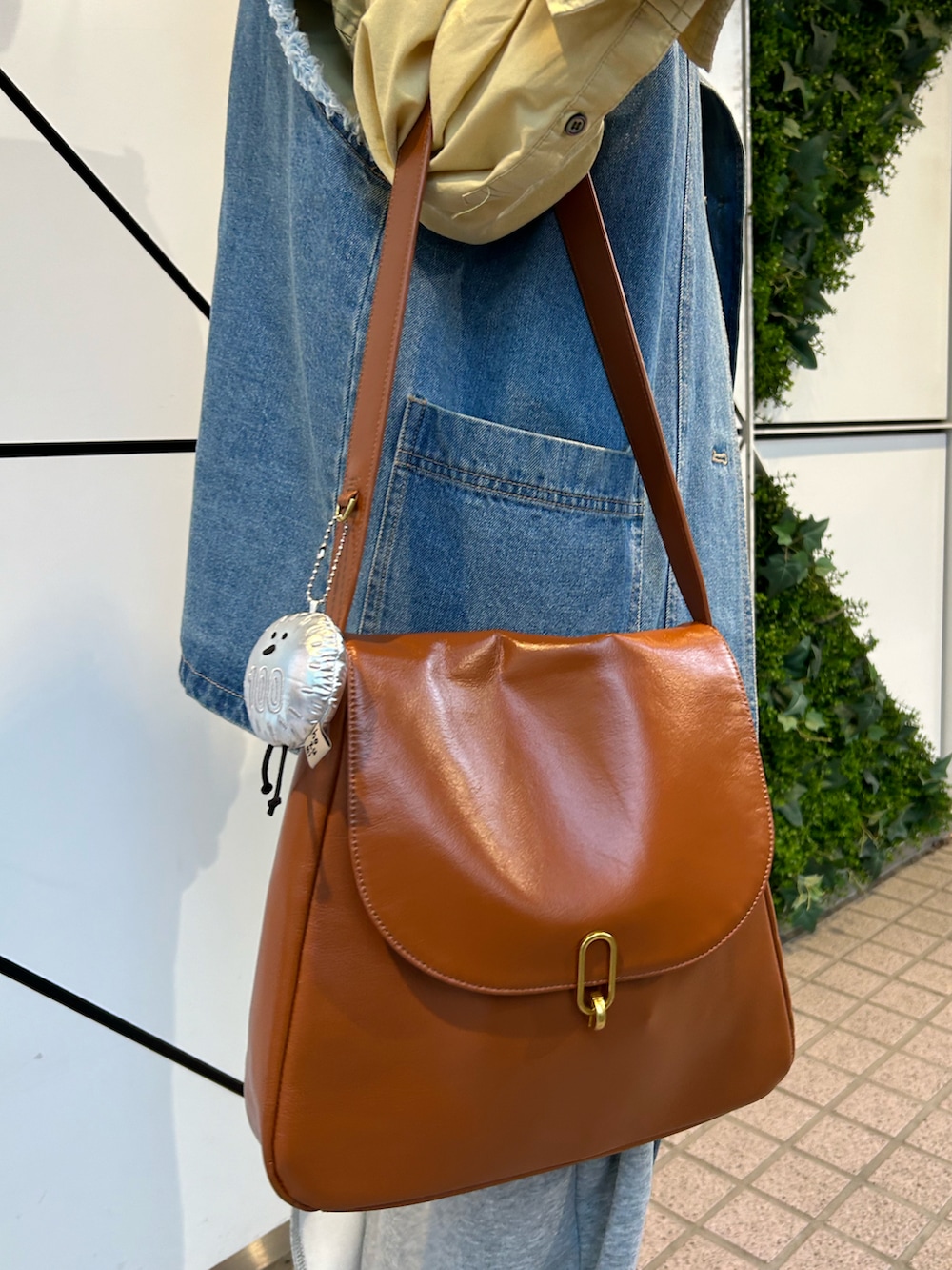 イエロー系のトートバッグ、グレー系のポーチ、その他のハンドケア/ハンドクリームを着用したレディースの春コーディネートの2枚目の写真