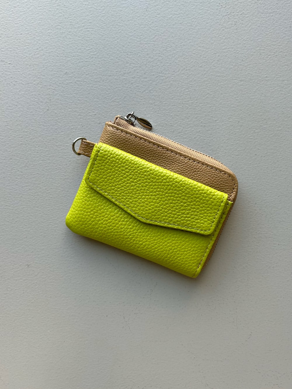 イエロー系のチャーム、ベージュ系の財布を着用したレディースの冬コーディネートの2枚目の写真