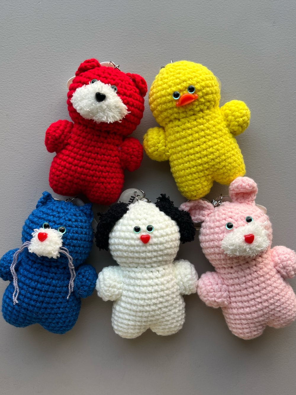 レッド系のキーケース/キーアクセサリー、イエロー系のポーチ、ピンク系のキーホルダーを着用したレディースの夏コーディネートの2枚目の写真