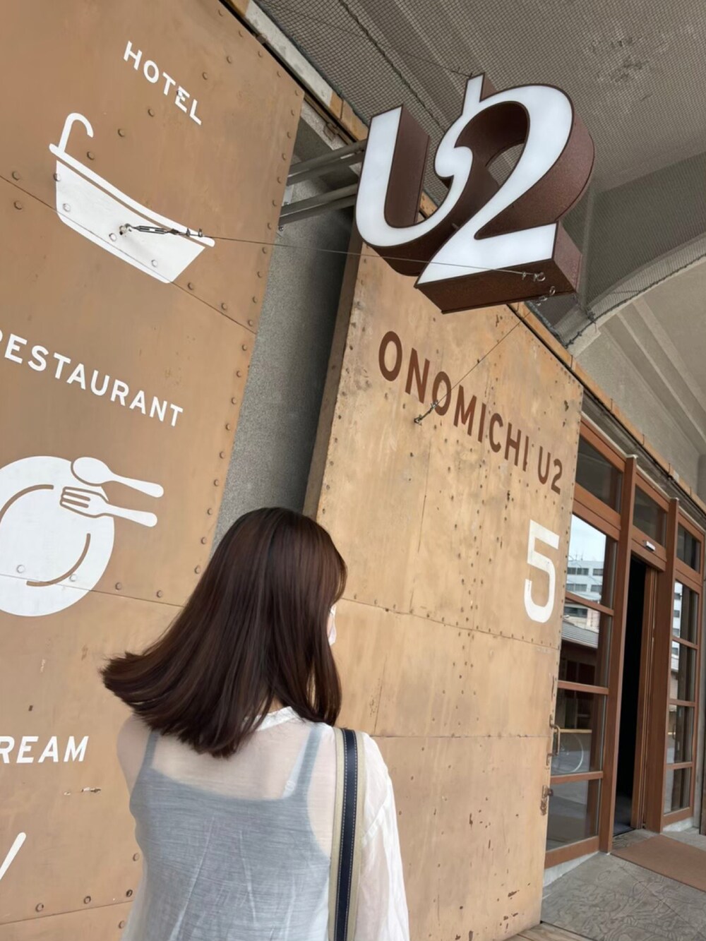 ホワイト系のシャツ/ブラウス、ブラック系のスラックス、ブラウン系のハンドバッグを着用したレディースの春コーディネートの3枚目の写真