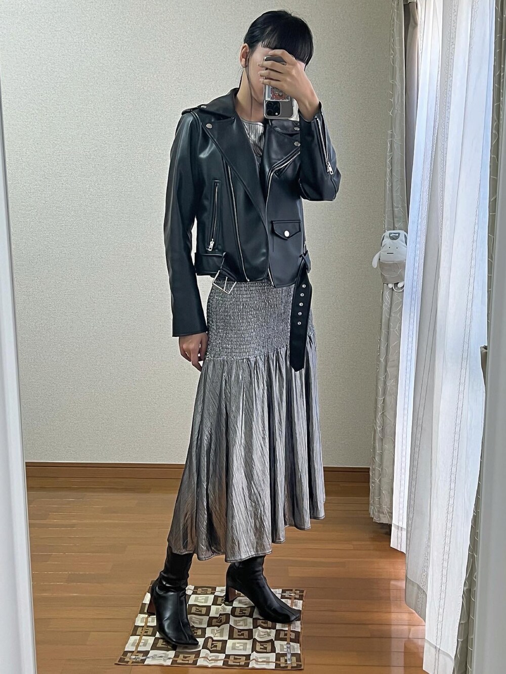 シルバー系のワンピース、ブラック系のブーツを着用したレディースの冬コーディネートの2枚目の写真