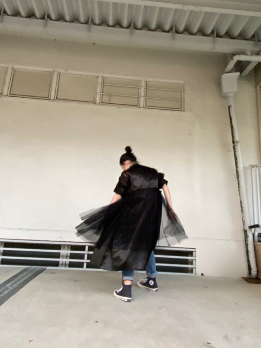 ブラック系のシューズ、ブルー系のデニムパンツを着用したレディースの春コーディネートの3枚目の写真