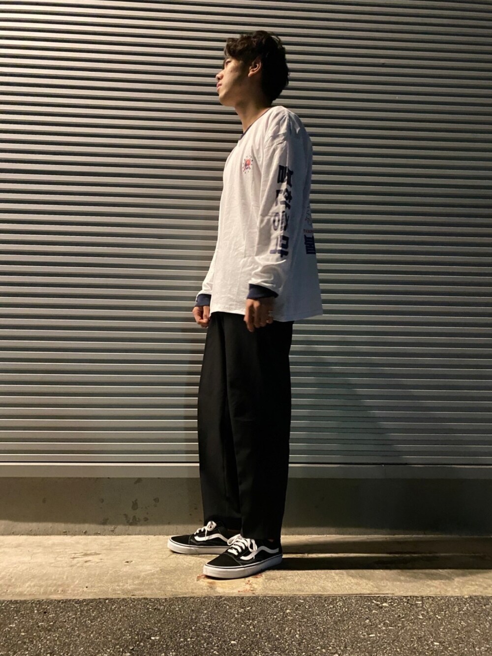 ホワイト系のTシャツ/カットソー、ブラック系のスラックス、ブラック系のスニーカーを着用したメンズの秋コーディネートの3枚目の写真