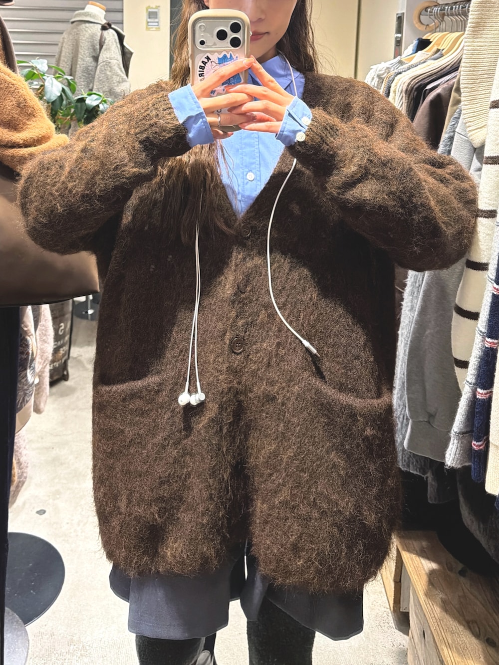 ブラウン系のカーディガン/ボレロ、ブルー系のシャツ/ブラウスを着用したレディースの冬コーディネートの2枚目の写真