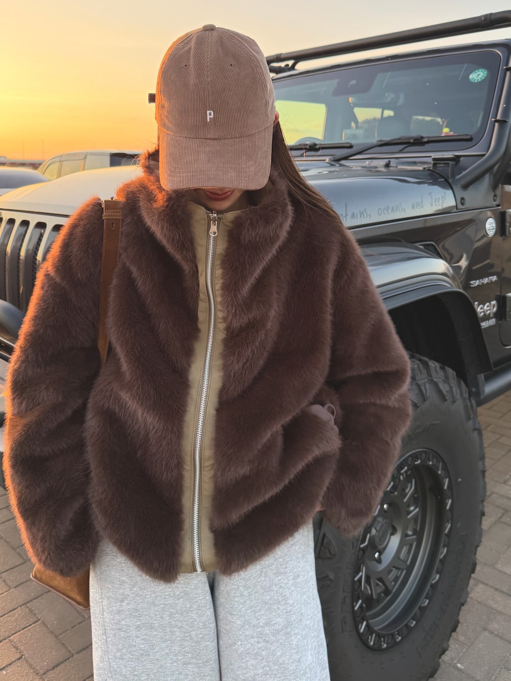 グリーン系のブルゾン、グレー系のスウェットパンツを着用したレディースの冬コーディネートの2枚目の写真