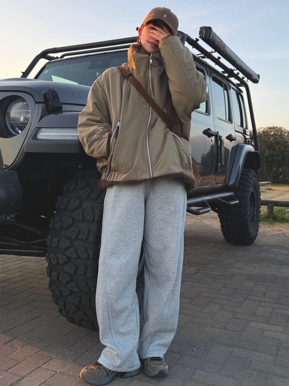 グリーン系のブルゾン、グレー系のスウェットパンツを着用したレディースの冬コーディネートの5枚目の写真