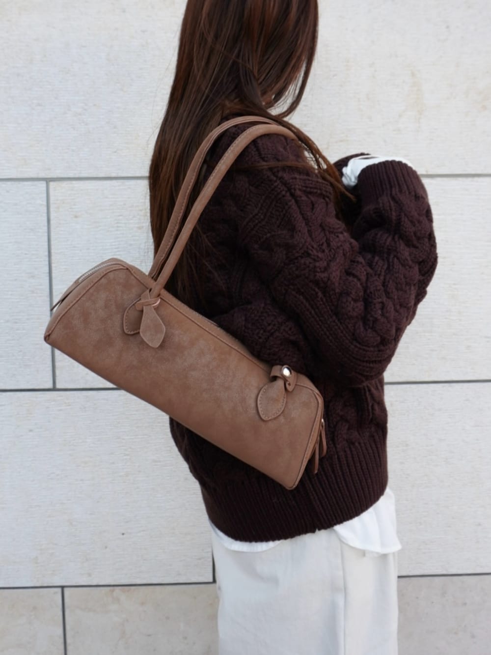 ブラウン系のニット/セーター、ホワイト系のパンツ、ベージュ系のショルダーバッグを着用したレディースの冬コーディネートの4枚目の写真