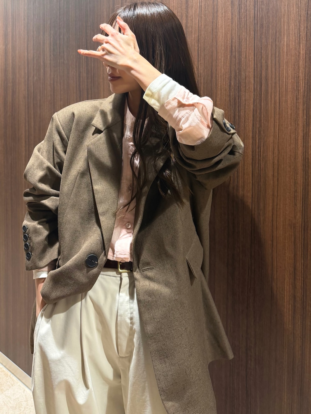 ピンク系のシャツ/ブラウス、ブラウン系のジャケット/アウター、ホワイト系のパンツを着用したレディースの春コーディネートの2枚目の写真