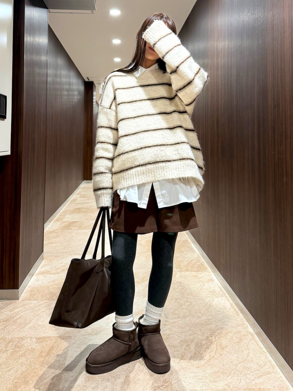 ホワイト系のニット/セーター、ブラウン系のブーツを着用したレディースの冬コーディネートの2枚目の写真