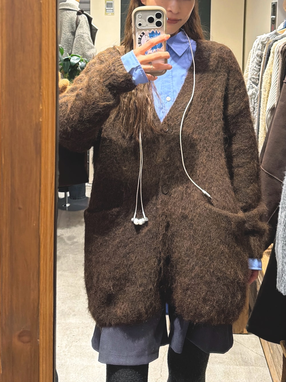 ブラウン系のカーディガン/ボレロ、ブルー系のシャツ/ブラウスを着用したレディースの冬コーディネートの3枚目の写真