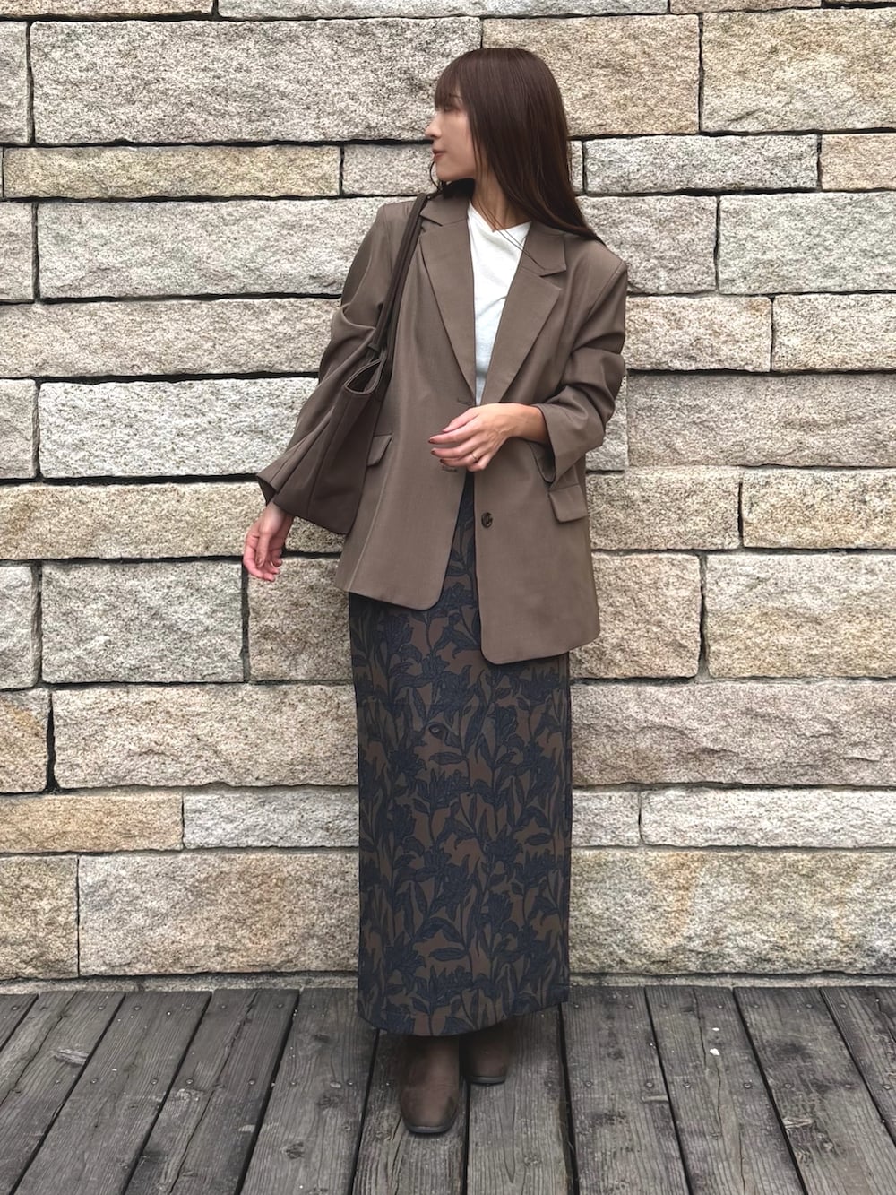 ブラウン系のブーツ、その他のテーラードジャケット、ブラウン系のスカートを着用したレディースの秋コーディネートの2枚目の写真