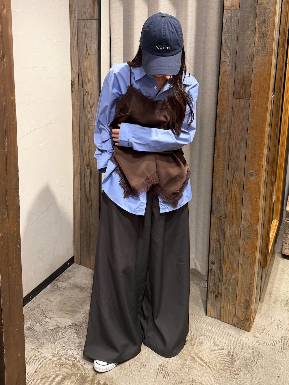 ブラウン系のキャミソール、グレー系のスラックス、ブルー系のキャップを着用したレディースの春コーディネートの2枚目の写真