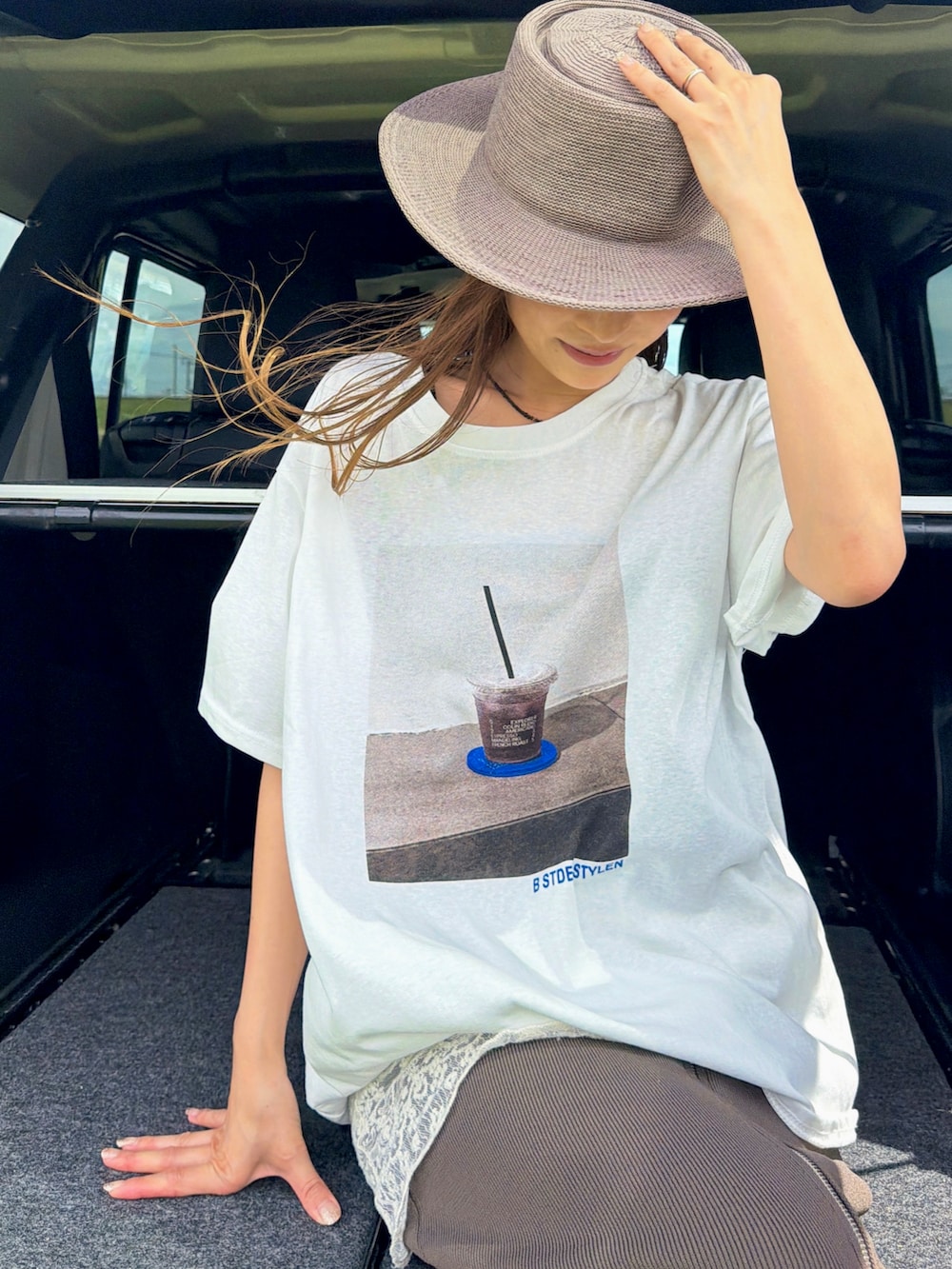 ホワイト系のTシャツ/カットソー、ブラウン系のハット、ホワイト系のストール/ショールを着用したレディースの夏コーディネートの2枚目の写真